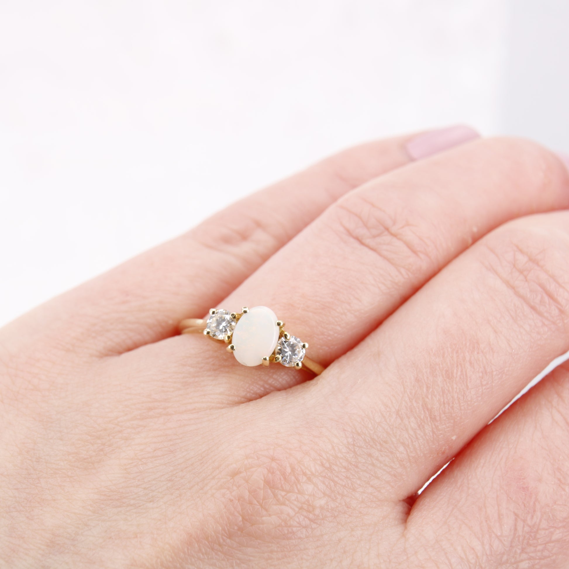 Pre-Owned Opal and Diamond three stone ring set in an exquisite 18ct yellow gold band . Her impressive 0.75ct opal offers beautiful flashes of colour and is partnered by round brilliant cut diamonds.