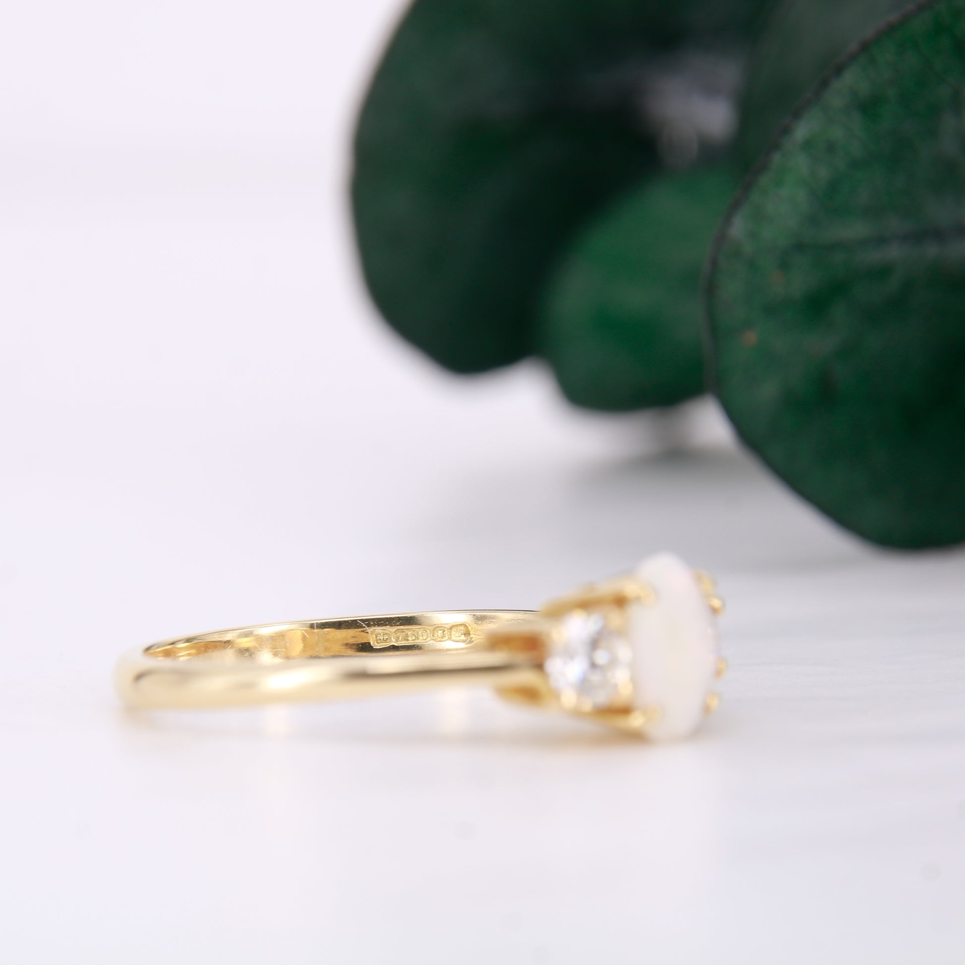 Pre-Owned Opal and Diamond three stone ring set in an exquisite 18ct yellow gold band . Her impressive 0.75ct opal offers beautiful flashes of colour and is partnered by round brilliant cut diamonds.