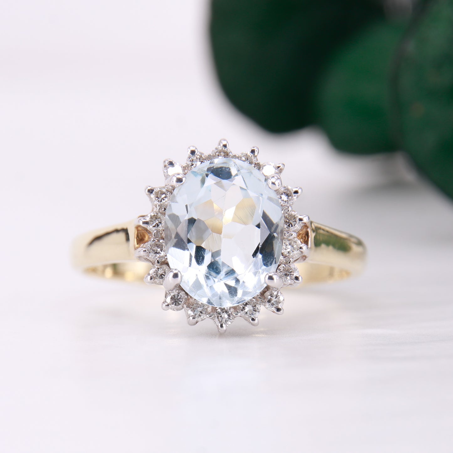 Preowned Aquamarine and Diamond Preowned Ring. Oval cut Aquamarine with a halo of diamonds set in 9ct yellow gold. 