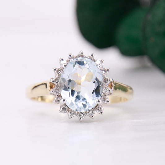 Preowned Aquamarine and Diamond Preowned Ring. Oval cut Aquamarine with a halo of diamonds set in 9ct yellow gold. 